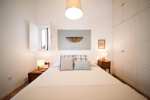una camera da letto con un grande letto bianco con due cuscini di Light Lovers Apartment a Lisbona