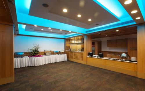 a large room with white tables and blue lighting at E Square The Fern, Pune in Pune