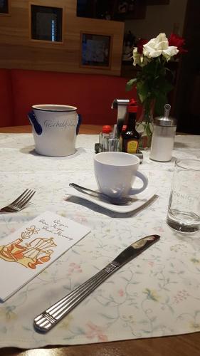 a table with a table cloth with a bowl and a knife at Gasthof Herlwirt in Ligist