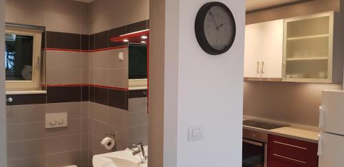 bagno con lavandino e orologio sul muro di Gavza Dream View apartment a Cres