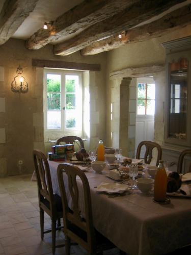 ein Esszimmer mit Tisch und Stühlen und Fenstern in der Unterkunft la Chambre des Dames in Vallères