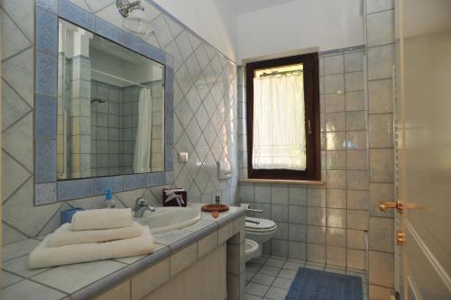 a bathroom with a sink and a toilet and a mirror at Belsit Bed&Breakfast in Porto San Giorgio