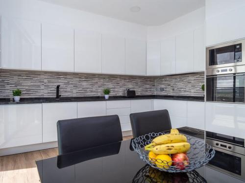 a kitchen with a bowl of fruit on a table at Villa Ria Alvor- Swimming pool & Jacuzzi in Mexilhoeira Grande