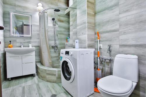 a bathroom with a washing machine and a toilet at Apartment Anano in Kutaisi