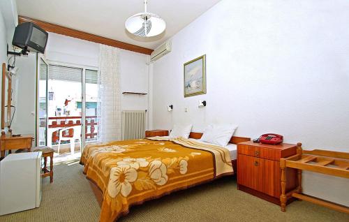 Hotel Helios في باراليا كاتيرينّيس: غرفة نوم فيها سرير وتلفزيون