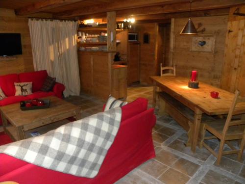 a living room with a red couch and a wooden table at CHALET GRINCH 90m2, 3 Sdb, skis aux pieds, wifi in Tignes