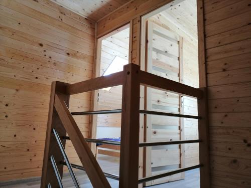 a room with a ladder in a wooden cabin at Domki Pod Gwiazdami in Władysławowo