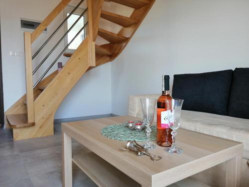 a table with a bottle of wine and glasses on it at Domki Pod Gwiazdami in Władysławowo