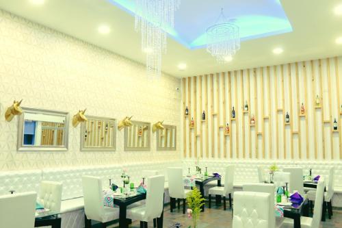 a dining room with white tables and white chairs at Hotel Boutique El Poblado in Neiva