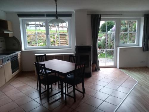 a kitchen with a table and chairs and two windows at Ferienwohnung Zechner in Waidring