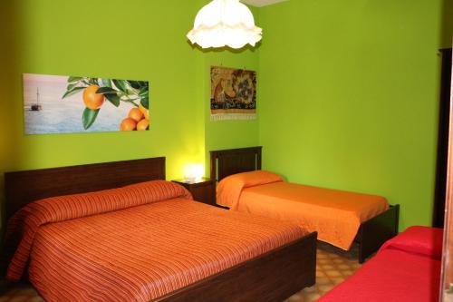 a room with two beds and green walls at Estate4Home - Orange Dreams in Sant'Agnello