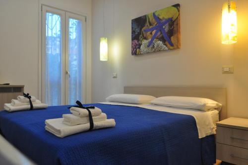 1 dormitorio con 2 camas y toallas. en B&B degli Aranci, en Palinuro
