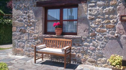 a bench sitting in front of a building with a window at La Quintana de Doña Leonor in Arriondas