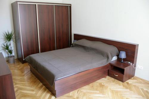 a bed with a wooden headboard in a room at Five Season's Apartment in Budapest