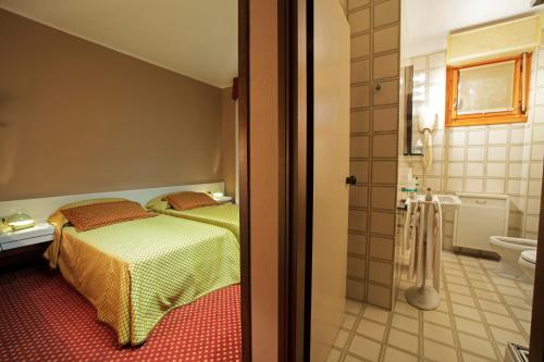 a bedroom with a bed and a bathroom at Hotel I Diamanti in Garlasco