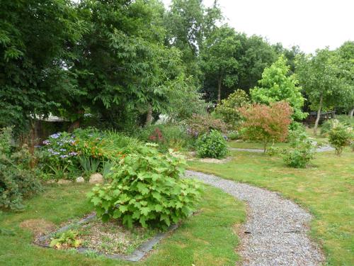 a garden with a gravel path and plants at Chambre d'hôtes Saint Jacob Relais de Chasse du XVIII Siècle in Les Fougerêts