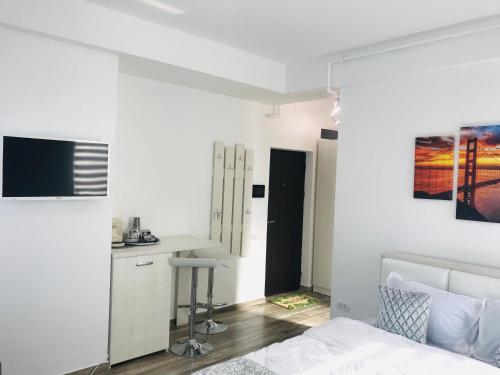 a white bedroom with a bed and a kitchen at Studio for 2 in Mamaia Summerland in Mamaia