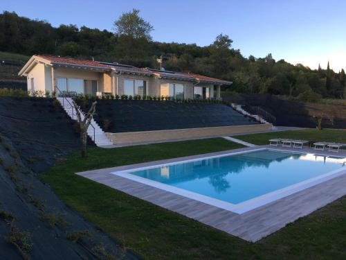 a house with a swimming pool in the yard at Villa Brusadela Suites Garda in Garda