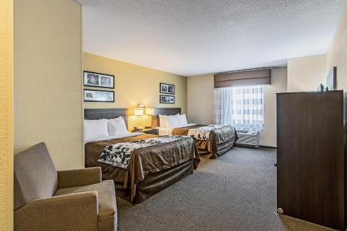 a hotel room with two beds and a chair at Sleep Inn & Suites West-Near Medical Center in Rochester