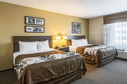 a hotel room with two beds and a window at Sleep Inn & Suites West-Near Medical Center in Rochester