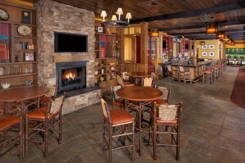 a bar with tables and chairs and a fireplace at Bear Creek Mountain Resort in Breinigsville