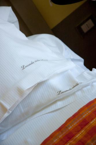a bed with white sheets with the word congratulations written on it at Locanda Delle Mura Anna De Croy in Magliano in Toscana