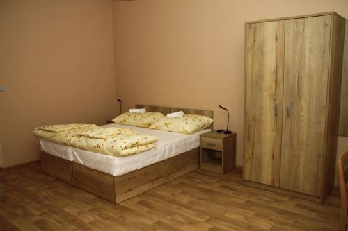 a bedroom with a bed and a wooden cabinet at Penzion Daníž in Chvalovice