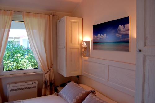 a bedroom with a bed and a window with a picture at Hotel Budoni Beach in Budoni