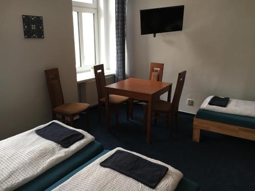 a room with a table and two beds and a window at Mikulov Inn - hotel Zeme in Mikulov