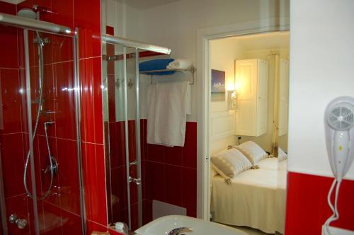 a bathroom with a shower and a bedroom with a bed at Hotel Budoni Beach in Budoni