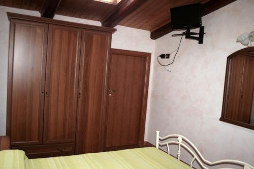 a bedroom with a bed and a wooden cabinet at Cascina Concetta in Pizzo