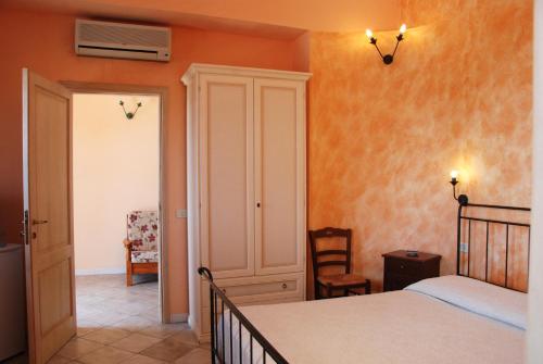 a bedroom with a bed and a room with a chair at Villa Fiori Beach in Menfi