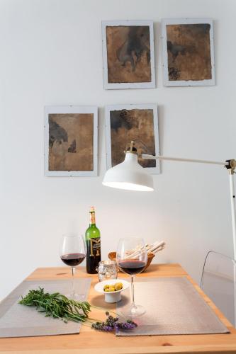 a table with two glasses of wine and a lamp at Graffiti Suites Málaga in Málaga