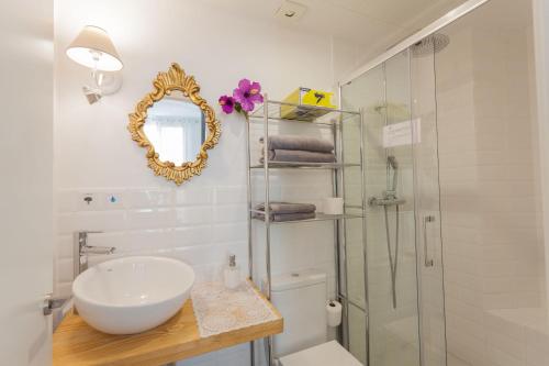 a bathroom with a sink and a mirror and a shower at Graffiti Suites Málaga in Málaga
