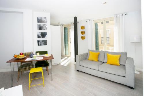 a living room with a couch and a table with yellow pillows at Graffiti Suites Málaga in Málaga