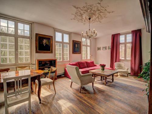 a living room with a red couch and a table at Haus Barkhausen in Monschau