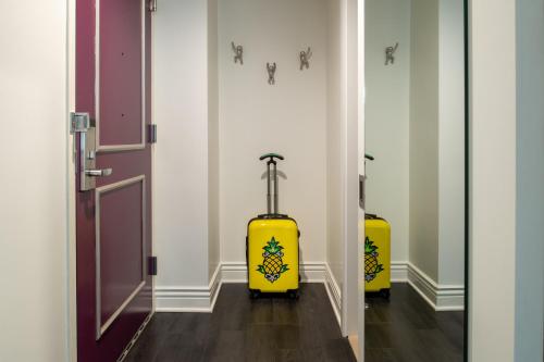 two yellow suitcases are sitting in a hallway at Staypineapple, An Artful Hotel, Midtown New York in New York