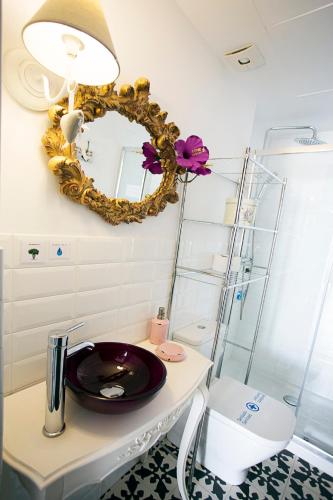 a bathroom with a mirror and a sink on a table at Graffiti Suites Málaga in Málaga