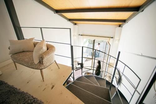 a living room with a chair and a staircase at Graffiti Suites Málaga in Málaga
