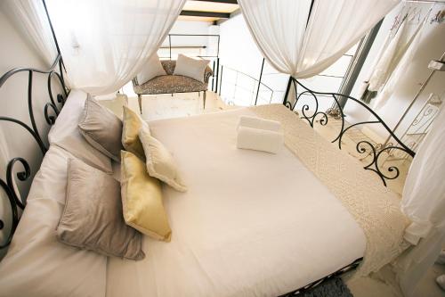 a large white bed with pillows on a balcony at Graffiti Suites Málaga in Málaga