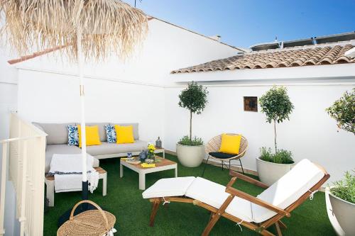 a patio with chairs and a couch and a table at Graffiti Suites Málaga in Málaga