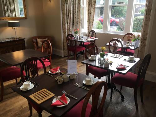 uma sala de jantar com mesas e cadeiras num restaurante em Ballifeary House em Inverness