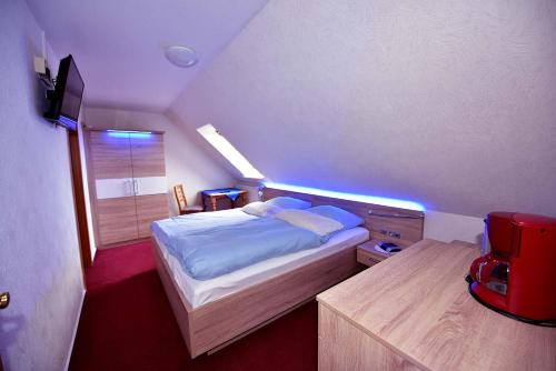 ein kleines Schlafzimmer mit einem Bett und einem Fenster in der Unterkunft Hotel-Restaurant England in Nordstrand
