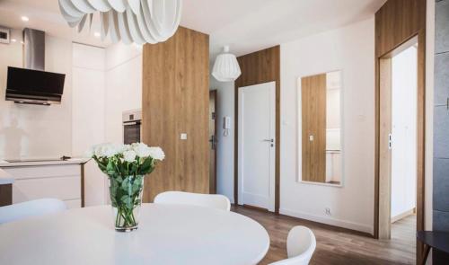 un comedor blanco con una mesa blanca y sillas blancas en Apartament w centrum Olsztyna - Grunwaldzka, en Olsztyn
