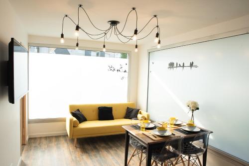 un salon avec un canapé jaune et une table dans l'établissement l’Inattendu, à Vannes