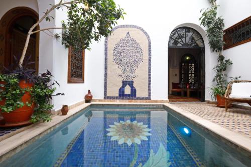 a swimming pool in a house with a tile wall at Riad Daria Suites & Spa in Marrakech