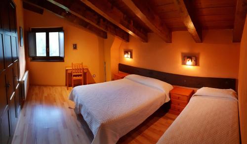 a bedroom with two beds and a window at Cal Sams in Olopte