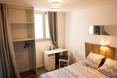 une chambre avec un lit, un bureau et une fenêtre dans l'établissement l’Inattendu, à Vannes