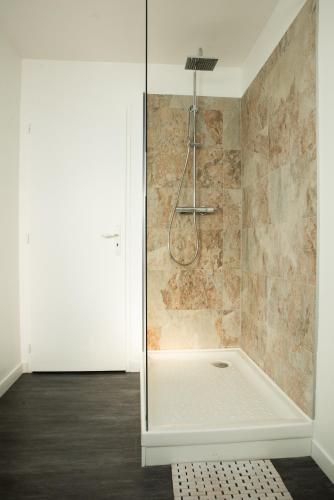 une douche avec une porte vitrée dans une salle de bain dans l'établissement l’Inattendu, à Vannes