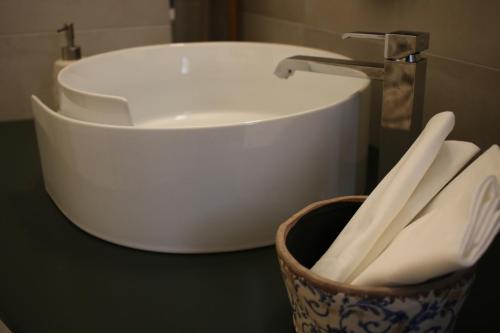 a bathroom with a sink and a basket of utensils at Piervì Suite in Putignano